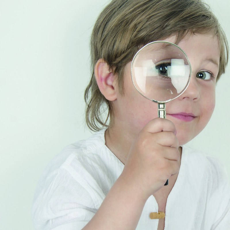 Bambino che osserva attraverso una lente d'ingrandimento: guardare da vicino per capire dove si può crescere.